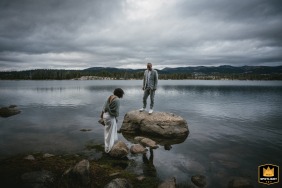 Calaveras, California, provides a natural setting as the bride and groom carefully walk together across large, scattered stones rising out of a scenic lake.